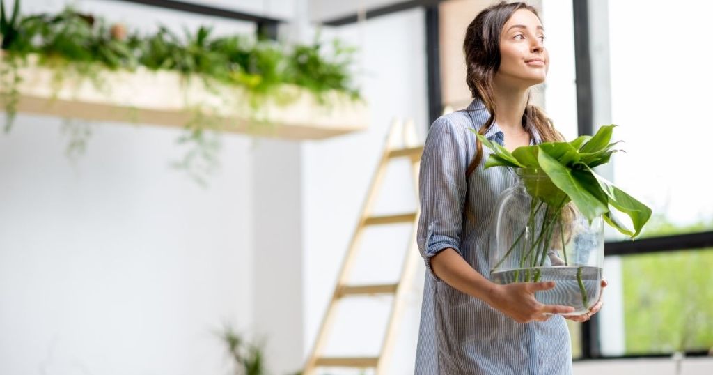 自宅で植物を持つ女性