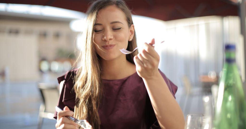 紫色の服を着た女性が食べる