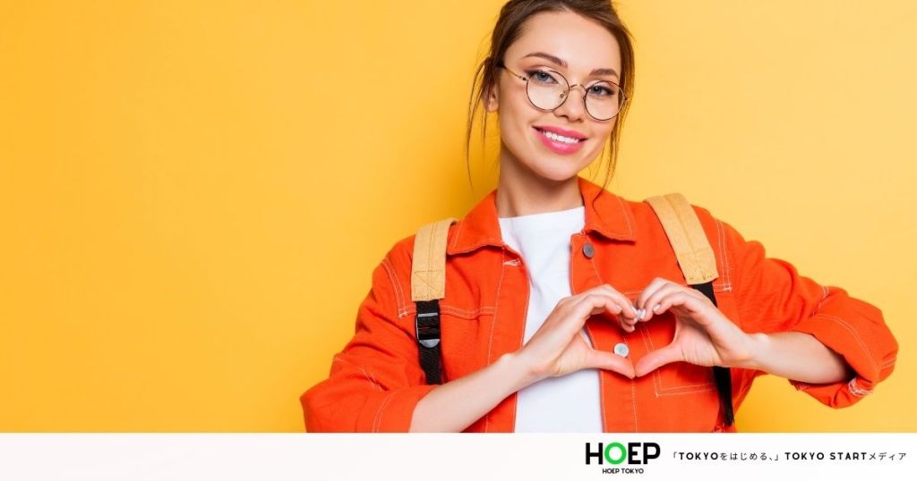 オレンジの服を着た大学生の女性